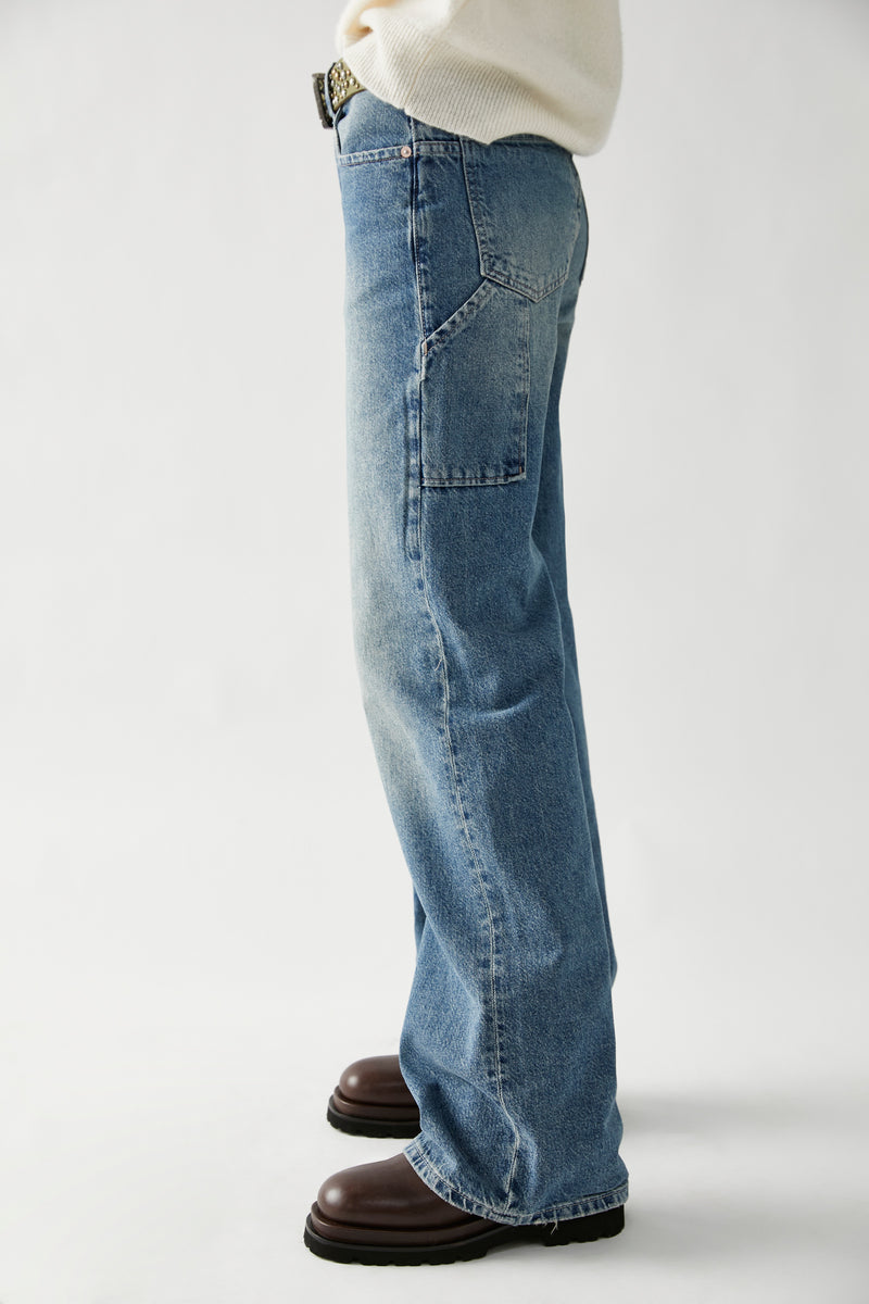side view of model in jeans. shows the carpenter detailing and baggy leg.
