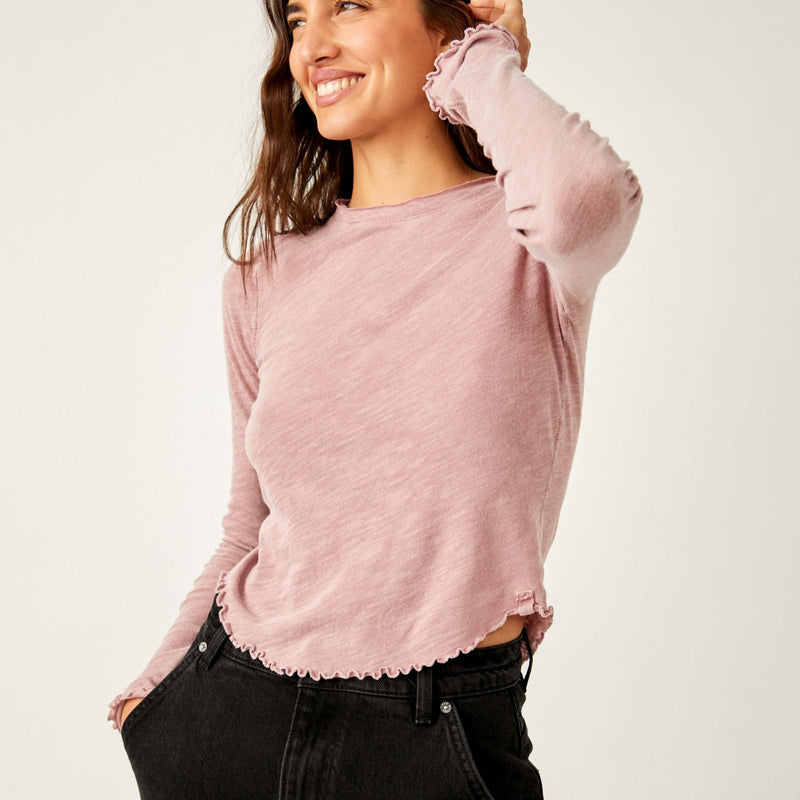 Front view of model wearing long sleeve. Shows the scoop neckline. Also shows the lettuce-style hems.