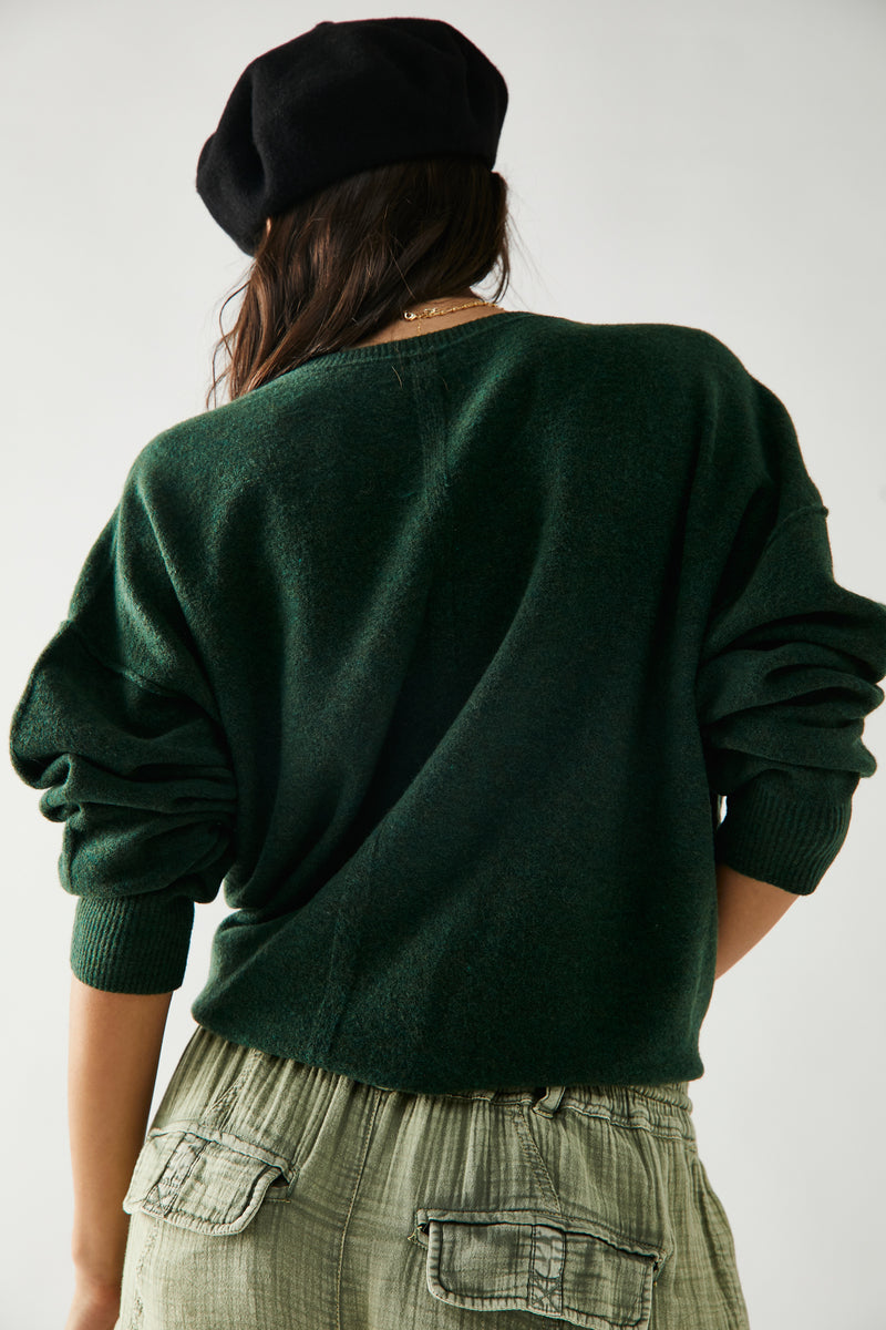 Back view of model wearing the pullover. Shows the slouchy, relaxed fit. Also shows seam running down the middle and exposed seaming. 
