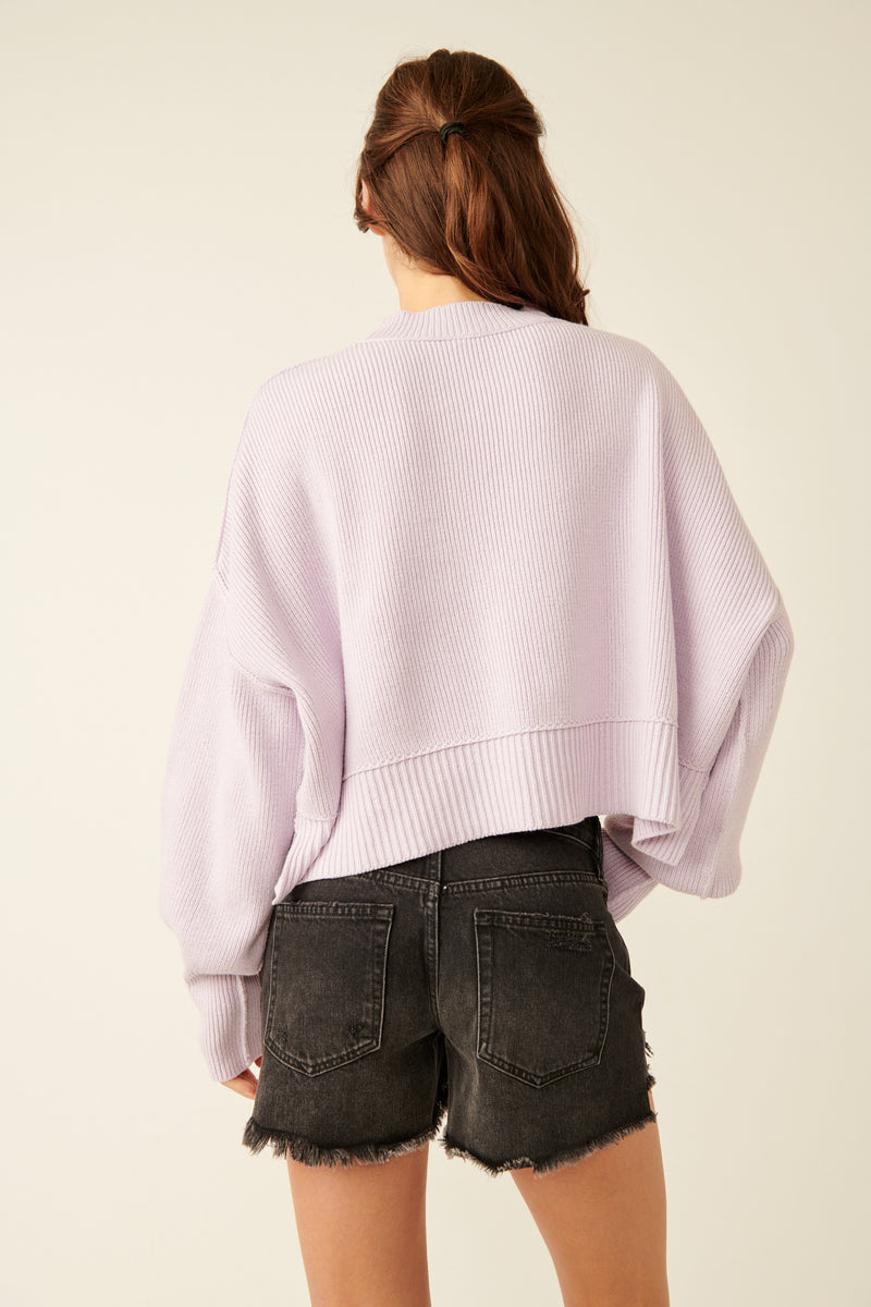 back view of model wearing the easy street crop pullover. shows the ribbed texture on the hem, cuffs and neckline. shows the drop shoulders, and the defined seaming. 