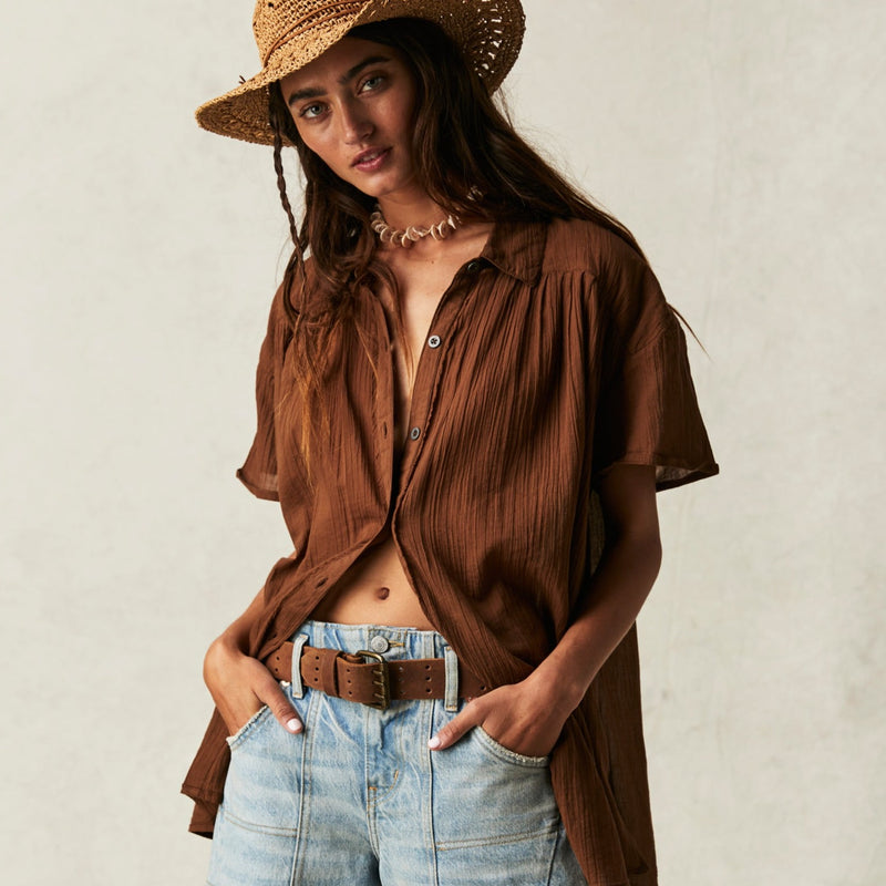 front view of the model wearing the float away shirt. shows the button down closure. also shows the classic collar, the dropped shoulders and the exaggerated pleating. 