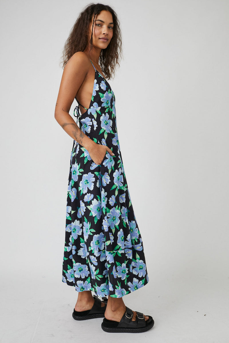 Side view of dress. Midi dress with side pockets shown. Open sides where strappy back is slightly shown.
