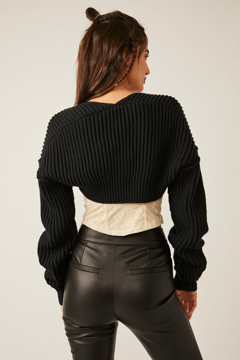 back view of model wearing shrug. here you can see the cropped length, dropped shoulders and long sleeves.