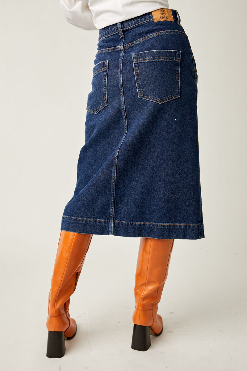 back view of model in skirt. shows back pouch pockets, a seam down the center and midi length.