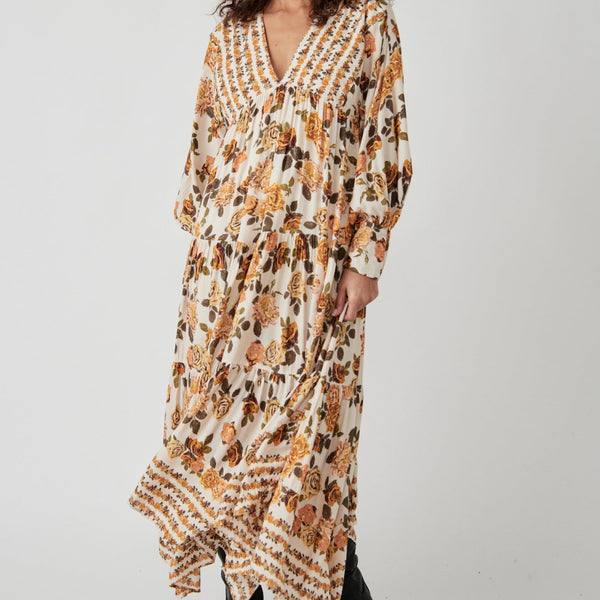 front view of model in dress. shows the v-neckline, empire waist, long sleeves and flowy skirt with all over floral print.