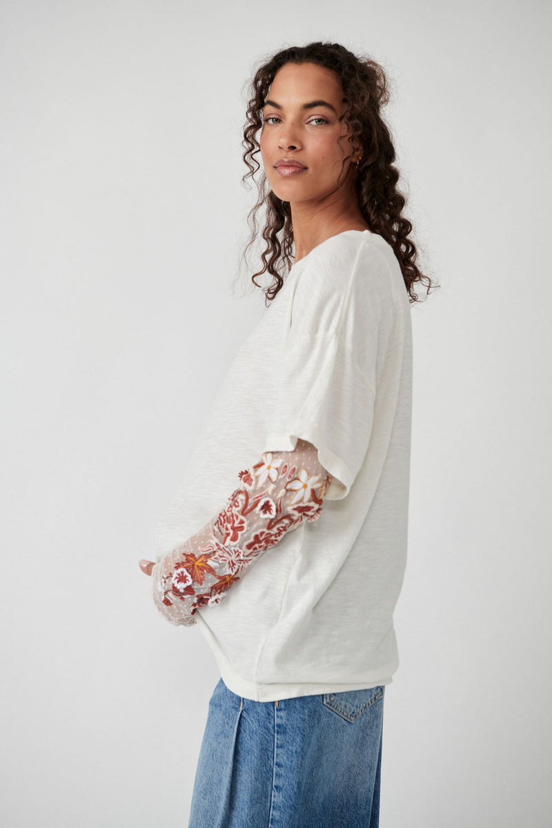side view of model in top. shows the dropped shoulders, oversized fit and sheer sleeves.