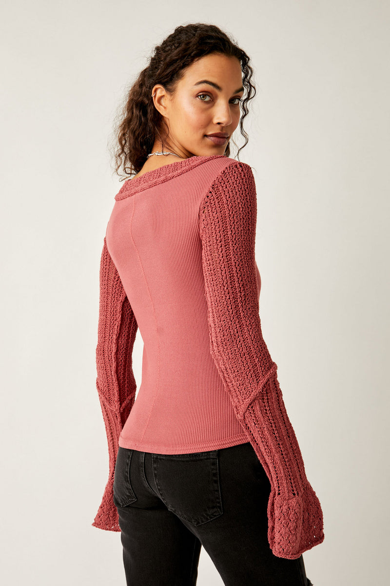 Back view of model wearing top. Shows the classic fit of the top. Also shows The hem down the back center and the bell sleeves. 