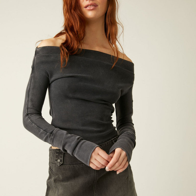 front view of the gigi long sleeve sleeve in black. shows the off the shoulder neckline. also shows the exaggerated sleeve, the slim fit and the ribbed detailing. 