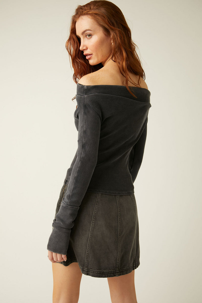 back/side view of the model wearing gigi long sleeve in black. shows the ribbed detailing. also shows the off the shoulder neckline, and the slim fit. 