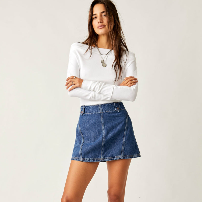 front view of model wearing the runaway denim skirt. shows the belt loops. also shows the three defined seamimg. 