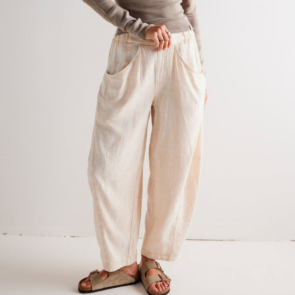 front view of the model wearing the high road pull on barrel pants. shows the dropped pouch pockets. also shows the ankle length, the tapered barrel silhouette and the mid rise.   