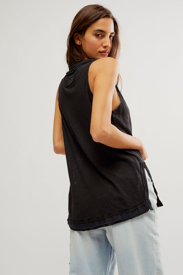 back view of the model wearing the love language tank. shows the dropped shoulders. also shows the side slits, the relaxed fit. 