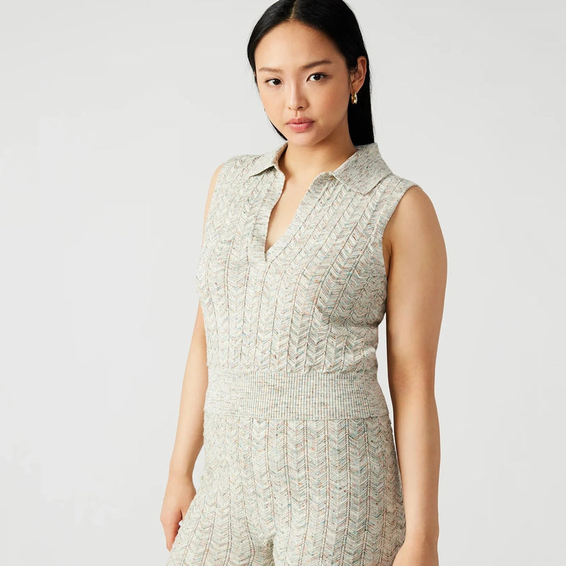 front view of the amina sweater. shows the sweater is sleeveless. also shows the open neckline, the ribbed heming and the cropped length. 