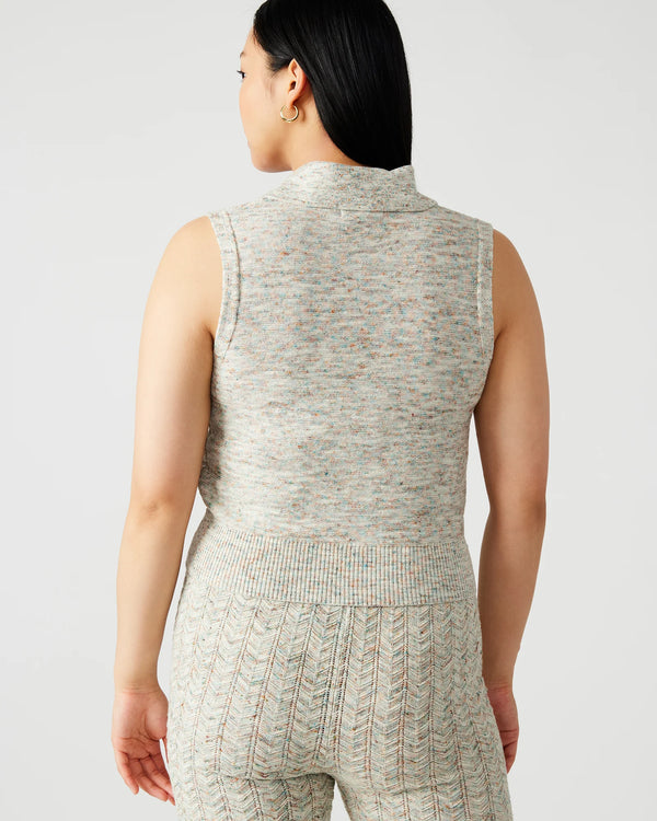 back view of the model wearing the amina sweater. shows that the sweater is sleeveless. also shows the collared neckline and the cropped length. 