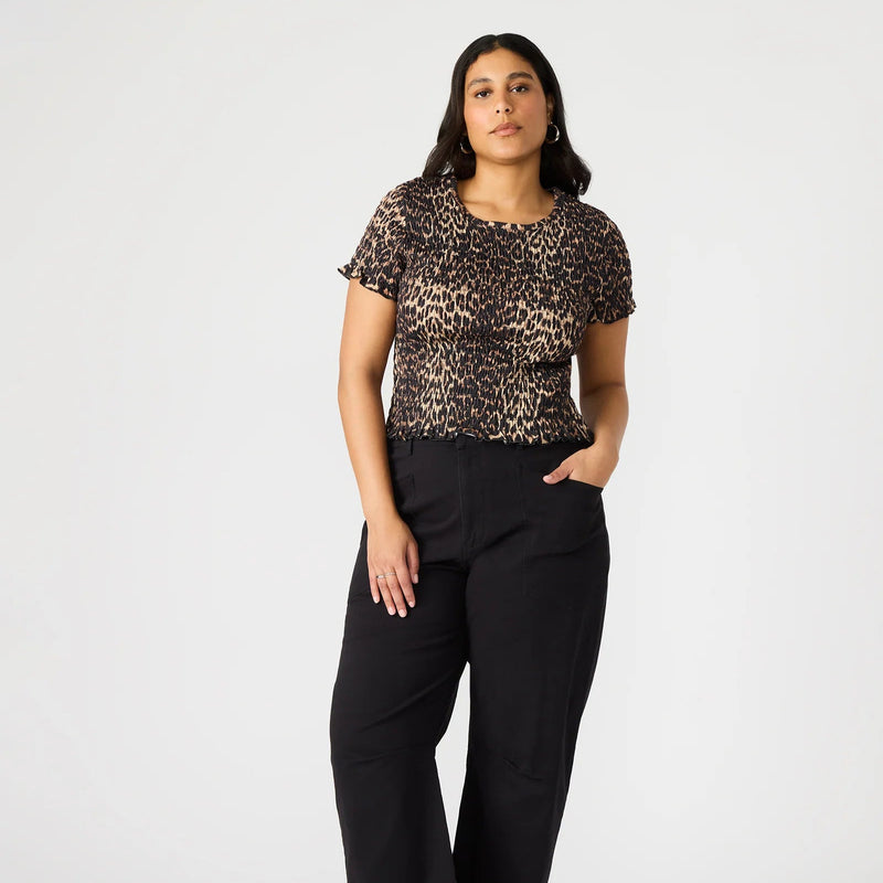front view of the model wearing the fia top. shows the cheetah print. also shows the smocking throughout, the lettuce trim on the hemlines and the short sleeve. 