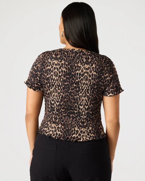 back view of the model wearing the fia top. shows the smocking throughout the shirt. also shows the cheetah print and the short sleeves. 