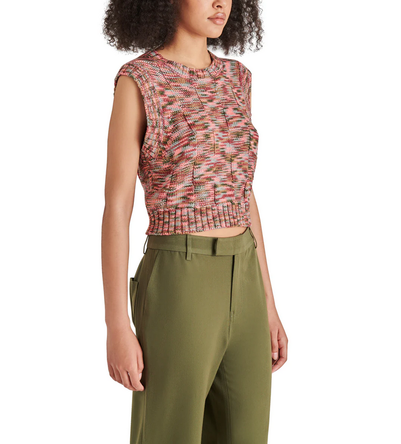 angled view of model in tank. shows the knit fabrication, sleeveless, crew neckline and slight cropping.
