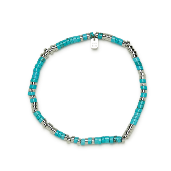 Stretch anklet is laying on a flat surface where you can see the flat blue and silver beads.