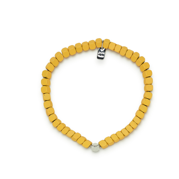 Shows bracelet laying on flat surface. Yellow coated hematite beads with one silver bead in center.