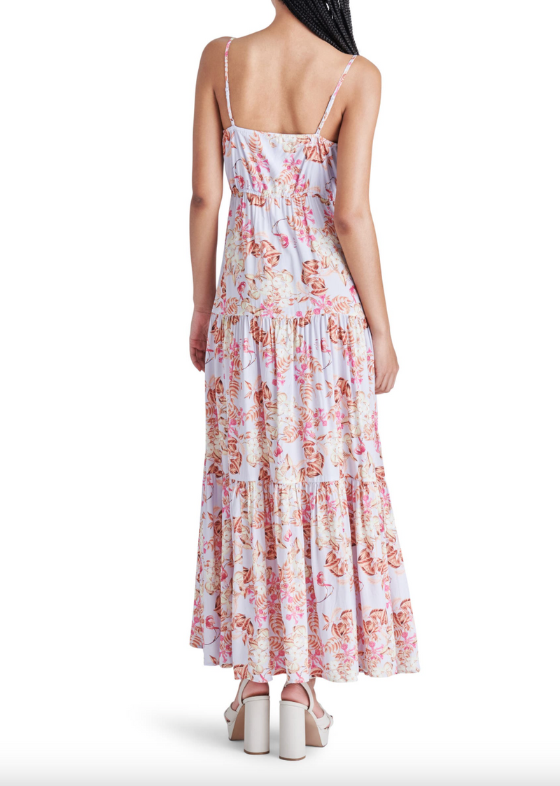 back view of model in dress. shows the adjustable spaghetti straps, straight back, tiered skirt and hits model at back of ankle.