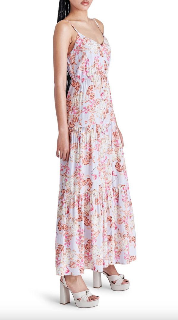 side view of model in dress. shows the flowy tiered skirt, length hits model at top of foot.