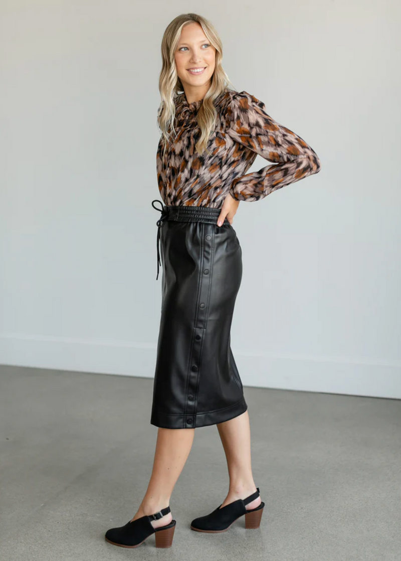 side view of model in skirt. shows the snap buttons on the side and midi length.