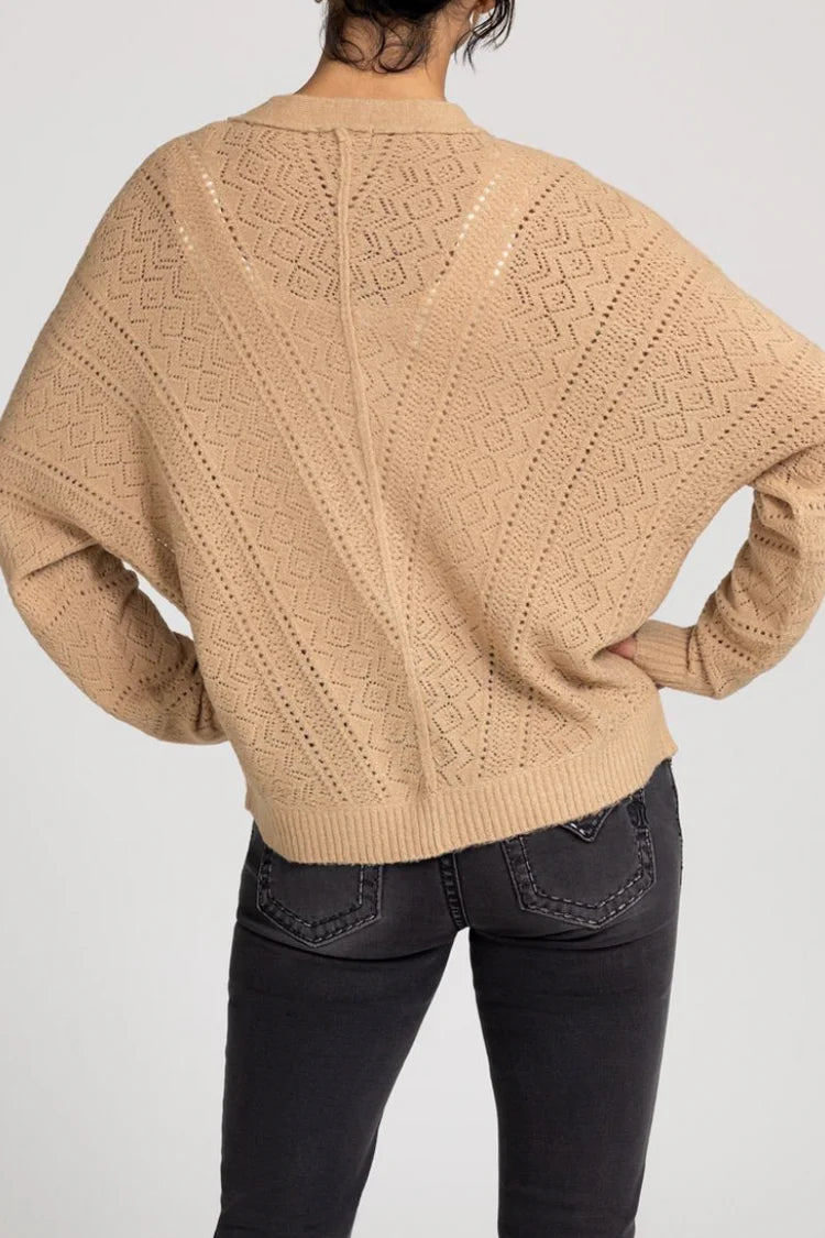 Beige knitted sweater with geometric pattern on a plain background