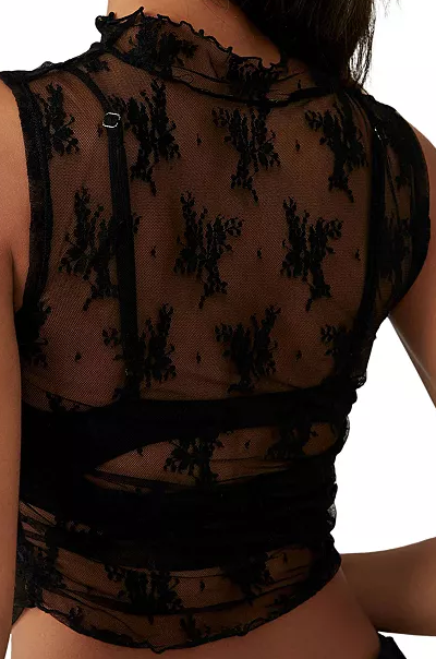 Black lace top worn by a person on a white background