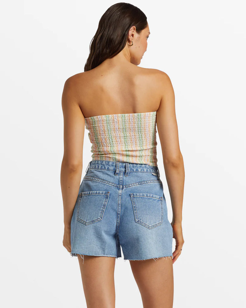 back view of the model wearing the riley shorts. shows the mid rise. also shows the frayed bottom hems and the back patch pockets. 
