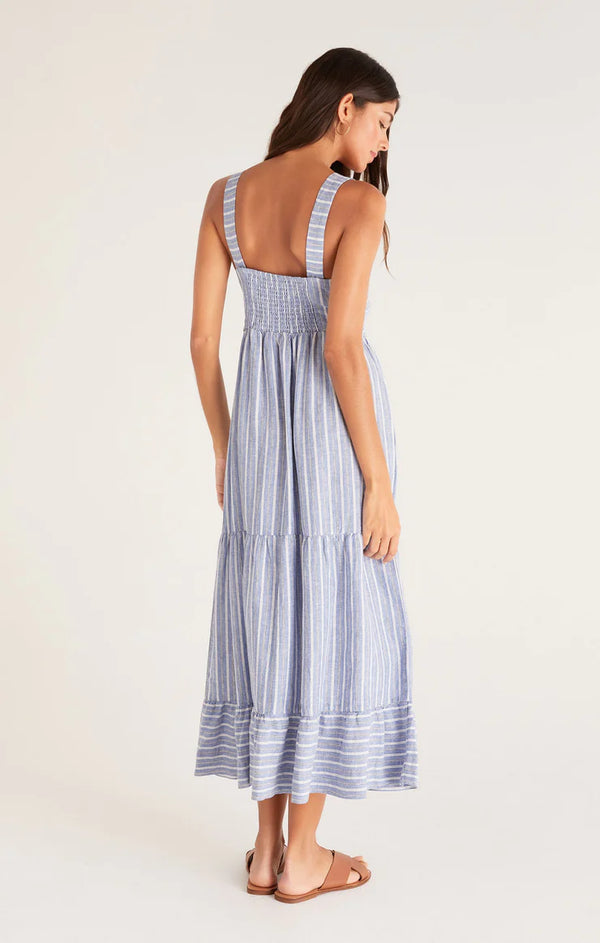 Shows the back of the dress. Features the smocked back, thick straps, and tiered skirt. Hits model at mid calf.