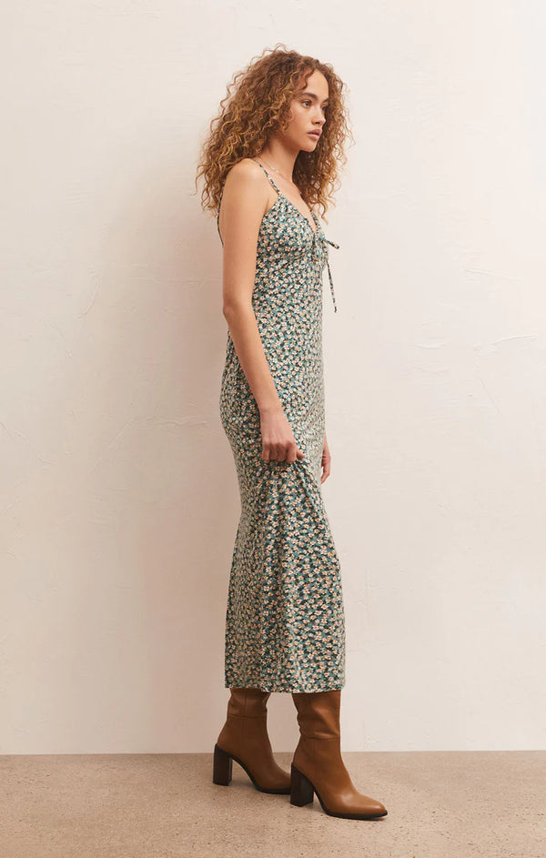 shows a side angle view of model in dress. shows the calf length detail as well as the skinny straps and tie detail.