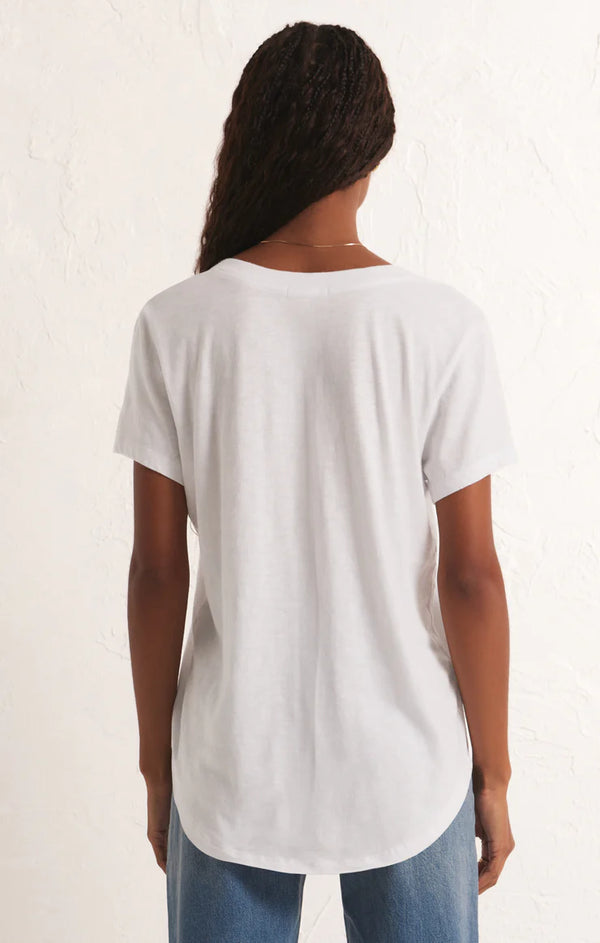 back view of the model wearing the asher v neck tee in white. shows the curved bottom hem. also shows the relaxed fit and short sleeves. 