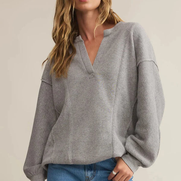 front view of the model wearing the out of towner sweatshirt. shows the Henley style. also shows the exposed seams, the relaxed fit, the dropped shoulders.  