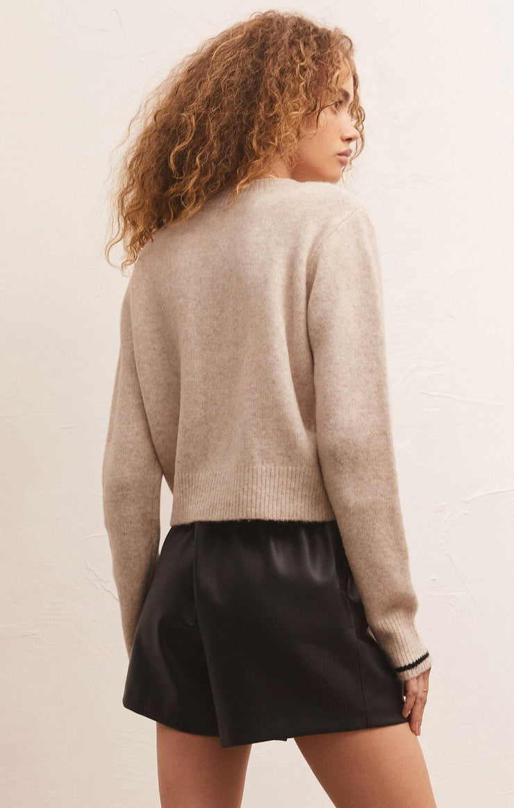 back view of model in sweater. shows the semi cropped length and looser fit.