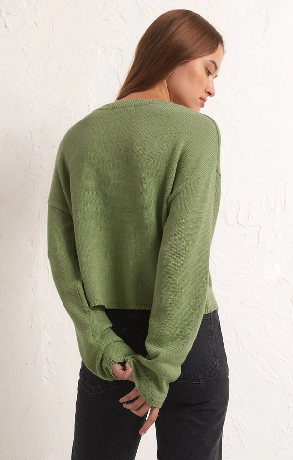 back view of the model wearing the cooper lucky sweater. shows the drop shoulders. also shows the relaxed fit, oversized sleeves and that the sweater sits at the waistline. 