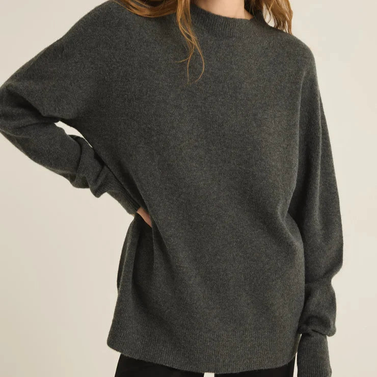 front view of the model wearing the gia crew neck sweater. shows the crew neckline. also shows the relaxed, oversized fit, the ribbed detailing and the longer length. 