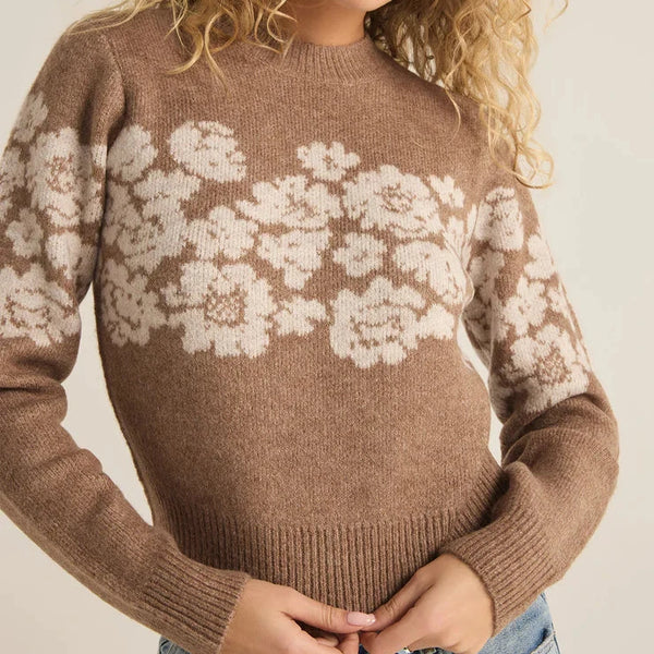 front view of the model wearing the marisol flora sweater. shows the crew neckline. also shows the ribbed detailing, the fitted style and the floral pattern. 