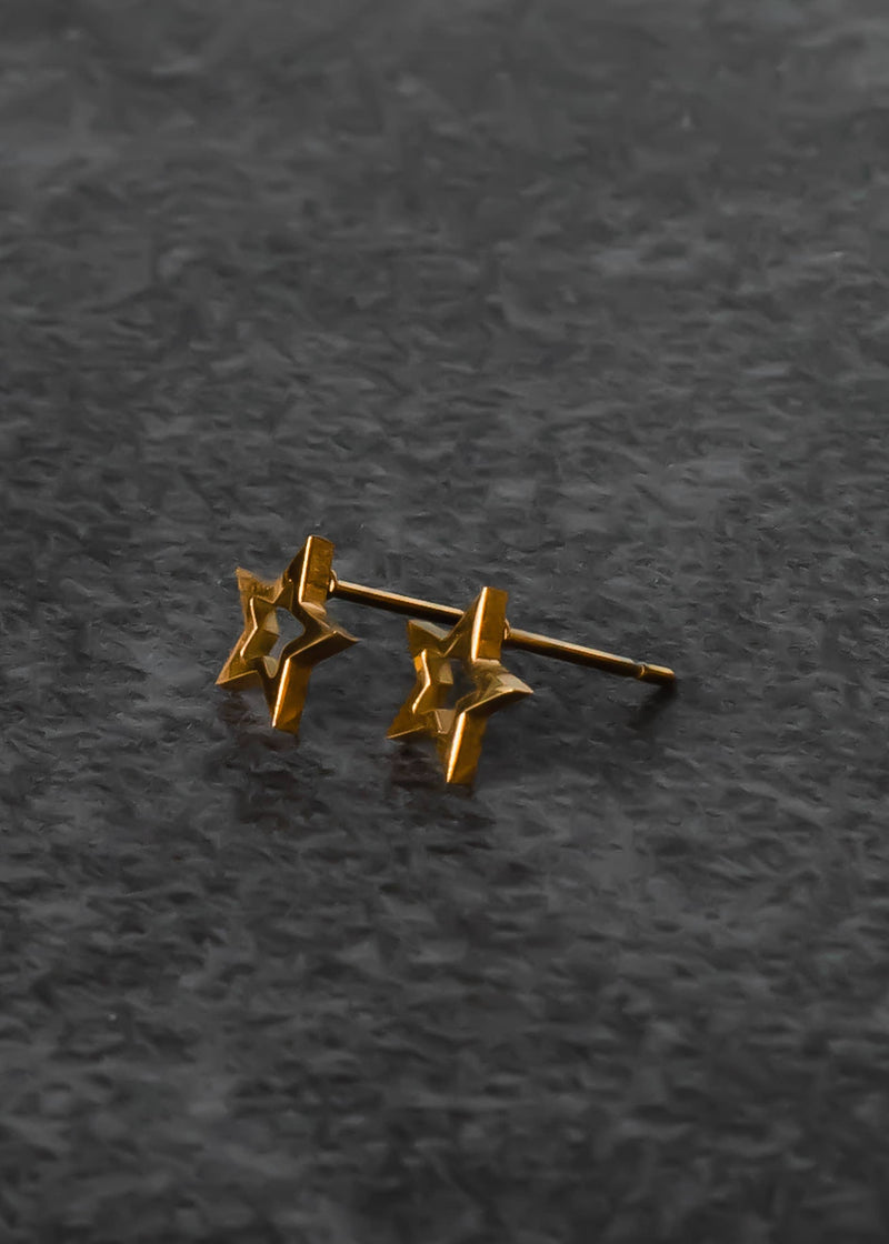 side view of the star studs. shows the stud backing, the star shaped and that it is opened in the middle and the gold color. 