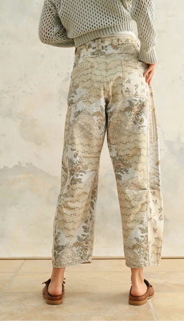 back view of the model wearing the dorothy printed barrel pants. shows the back patch pockets. also shows the barrel style, the all over floral print and the ankle length. 