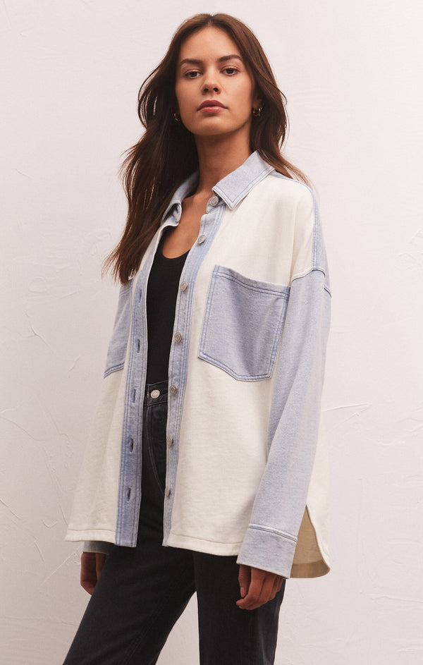 angled front view of model in jacket. here you can see the dropped shoulders as well as side slits on bottom hem.