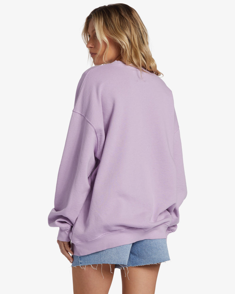 back view of the model wearing the ride in crewneck sweatshirt. shows the dropped shoulders. also shows the oversized fit, and the ribbed bands. 