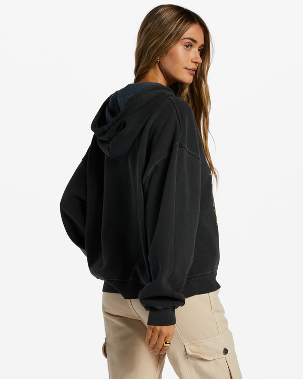Back/side view of model wearing hoodie. Shows the hood. Also the oversized fit. 