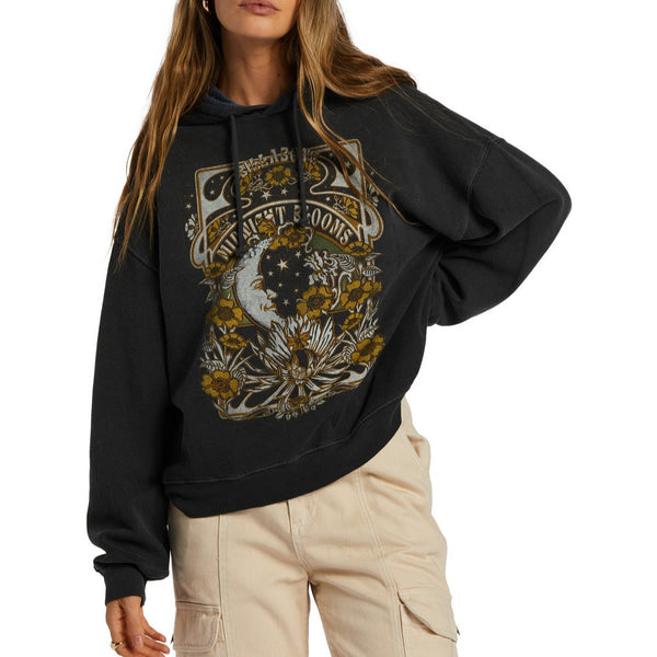 Front view of model wearing hoodie. Shows the drawstring cord. Also shows the oversized fit and the beautiful graphic with yellows and greens and says midnight blooms with flowers. 
