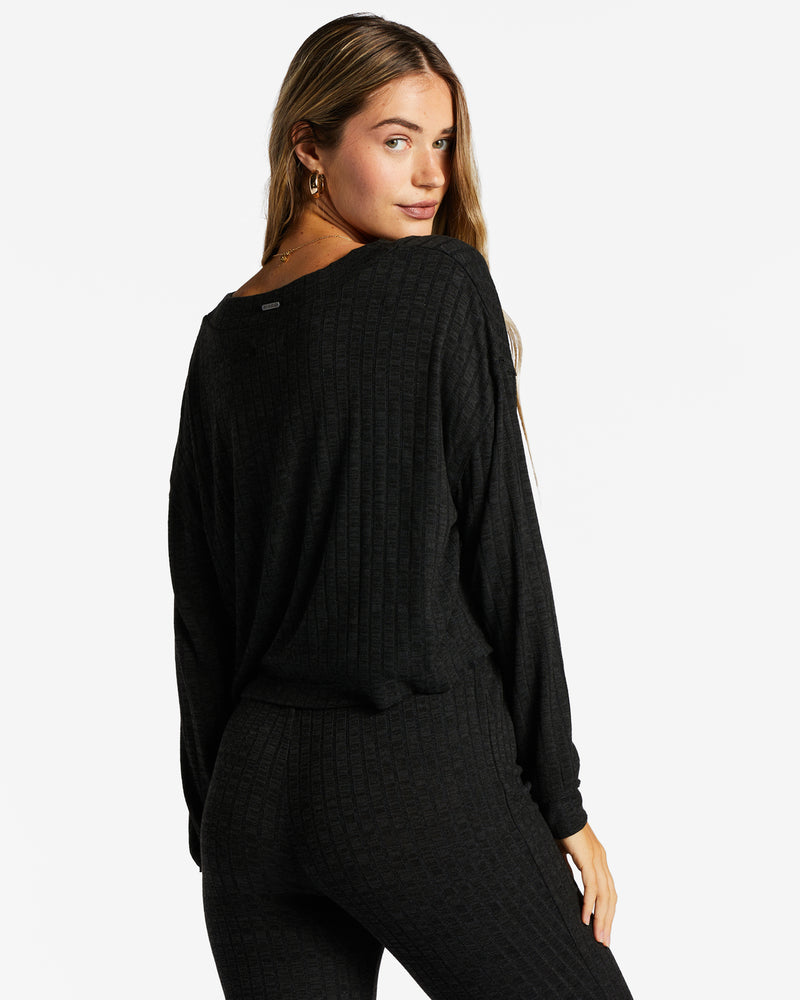 back view of model in cardigan. shows cropped length, dropped shoulders and boxy fit.