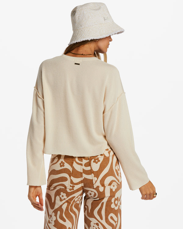 Back view of model wearing top. Shows the exposed seams on the drop shoulders. Also shows the cropped fit and long sleeves. 