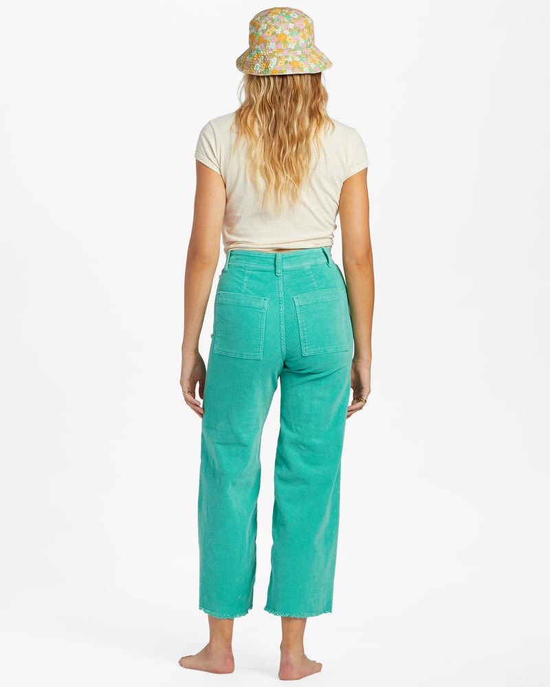 back view of the model wearing the free fall wide leg cord pant. shows the back patch pockets. also shows the wide leg, the raw hem and the belt loops. 