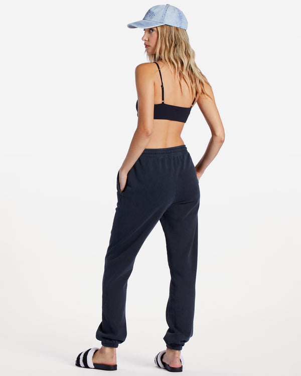 back view of model in sweatpants. high elastic waist is visible as well as the straight legs with elastic ankle cuffs.
