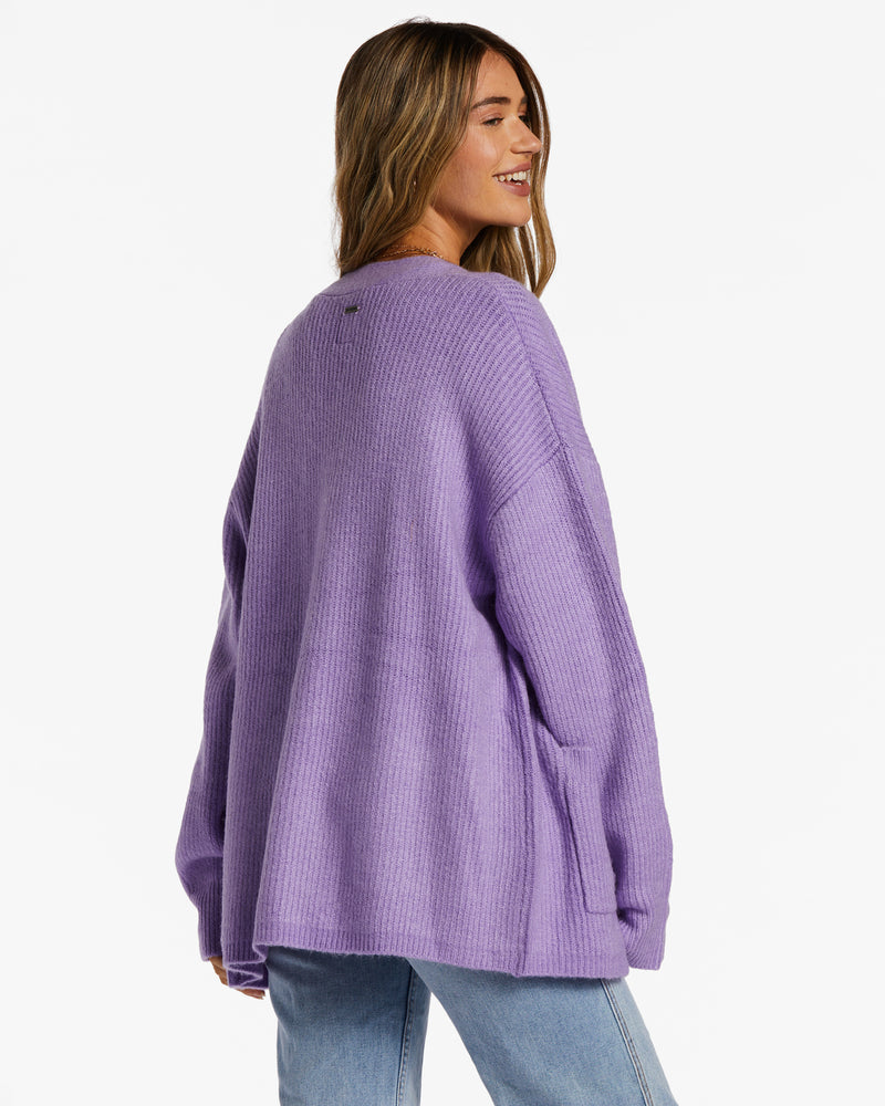 back view of model in cardigan. shows dropped shoulders and oversized fit.