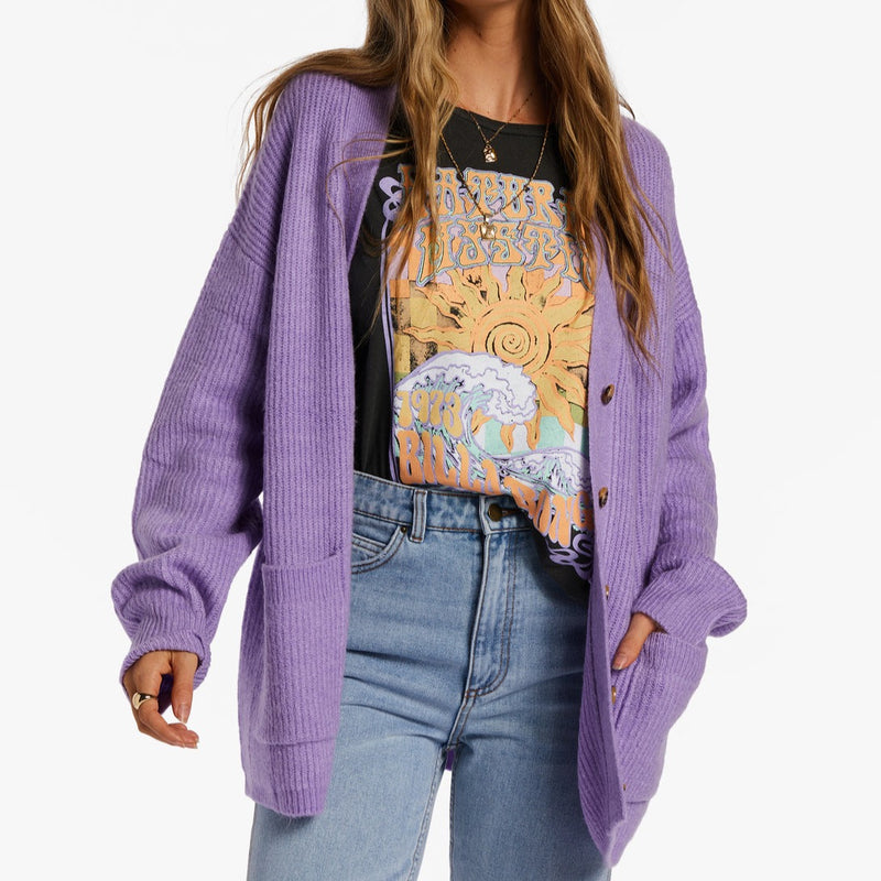 shows front view of model wearing the cardigan open. shows the dropped shoulders, long sleeves and front pouch pockets.