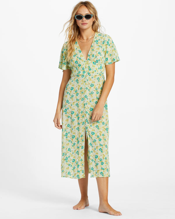 front view of the model wearing your girl dress. shows the deep v neckline. also shows the short flutter sleeves, the button closure and the smocking at the back waist. 